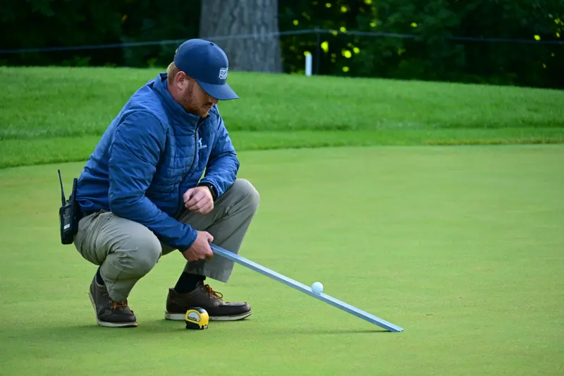 Ryan Paul uses a stimpmeter to measure the green speed during the 2026 Women's PGA Championship